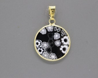 May include: A gold pendant with a black and white circular glass design featuring intricate floral patterns.