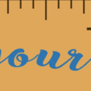 May include: A wooden ruler with inch markings and the phrase "Follow your dreams" in blue script. Blue arrow designs flank the text, adding a decorative touch to the inspirational message.