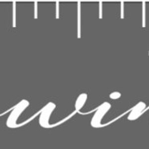 May include: A gray background with a white ruler and the words "Our Growing Family" in elegant script. The ruler is marked with white lines and numbers, suggesting a measurement tool or growth chart.