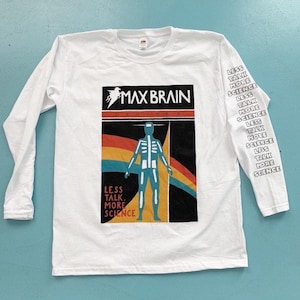 May include: White long-sleeve t-shirt with a black and white graphic of a skeleton with the text "Max Brain Devices" and the phrase "Less Talk More Science" on the front. The sleeve has the phrase "Less Talk More Science" repeated.