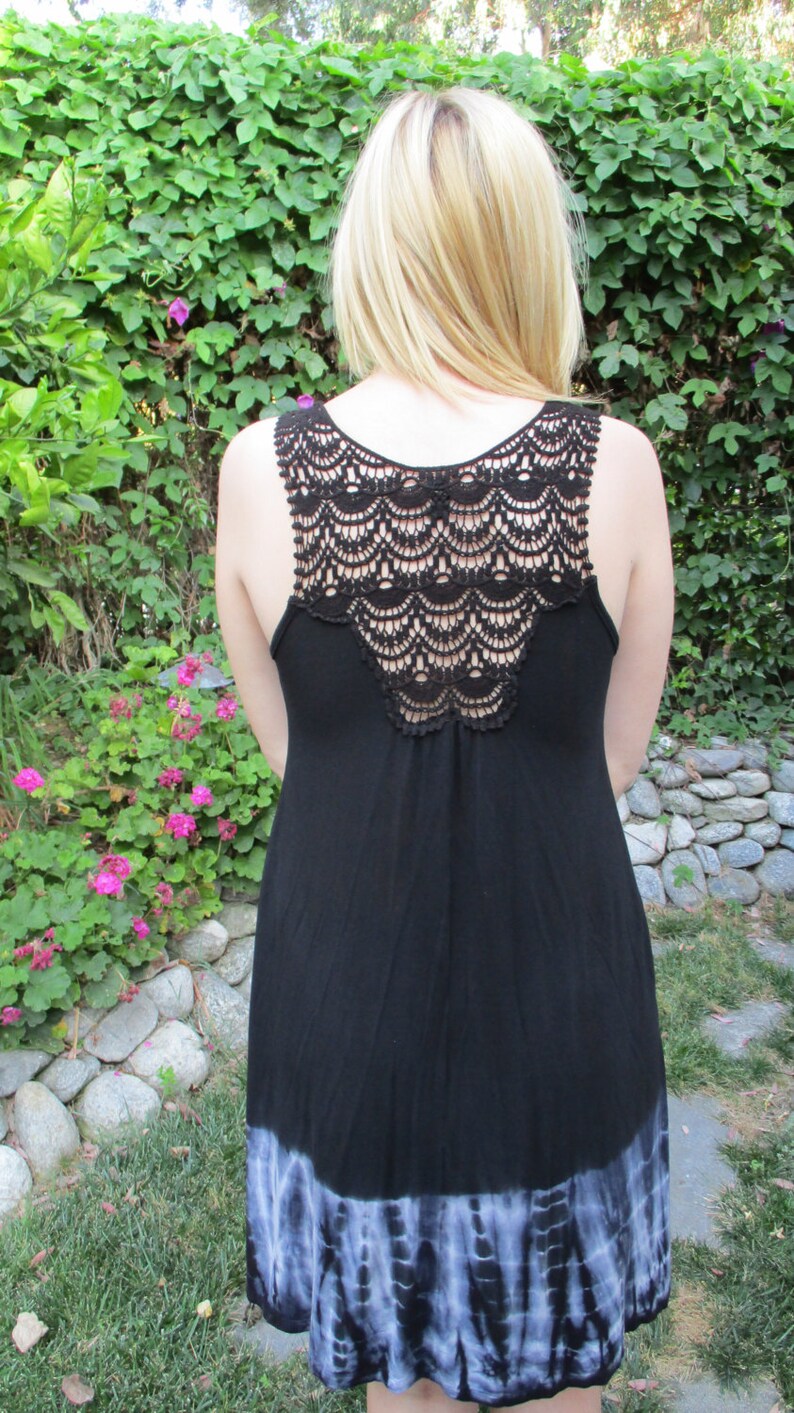 May include: A black sleeveless dress with a crocheted back and a tie-dye hem.