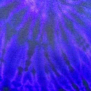May include: A close-up of a tie-dye fabric with a swirling pattern of dark blue and purple.