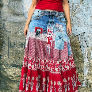 Puede incluir: Una falda larga de varios niveles con cintura y sección superior de mezclilla azul con detalles de parches, que transiciona a una tela roja con patrones florales blancos y un borde inferior decorado con un estampado de tulipanes.