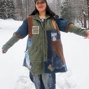 Pode incluir: Casaco patchwork com painéis em ganga, verde-oliva e castanho. O casaco apresenta múltiplos bolsos, remendos e um design único. A pessoa na imagem usa um chapéu e jeans a condizer, num cenário exterior com neve.