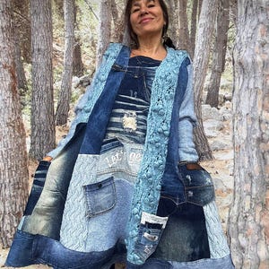 May include: A patchwork denim coat in various shades of blue. The coat features pockets, a knitted blue collar, and the text "Let's go" on the front. The coat is a unique, handcrafted piece.