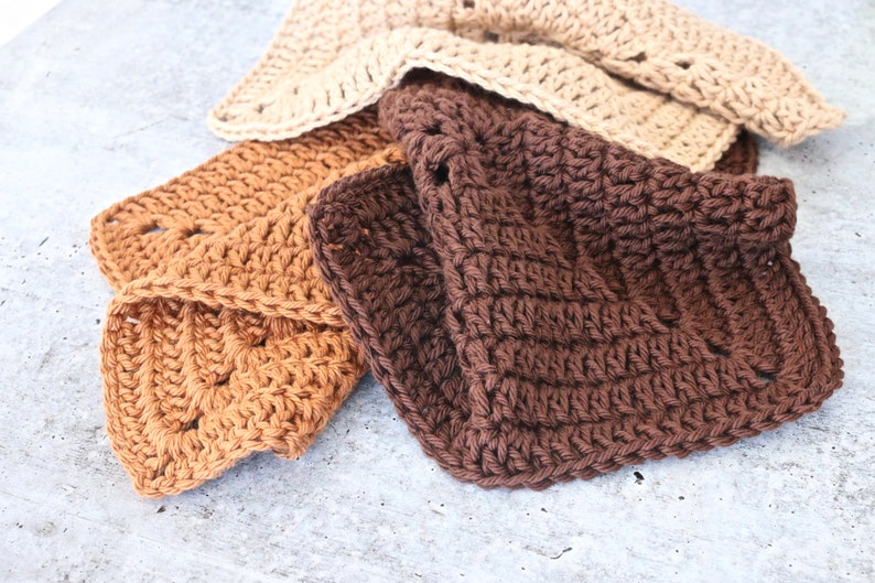 May include: Three crocheted dishcloths in brown, tan, and beige. The dishcloths are made with a simple stitch pattern and have a textured surface.