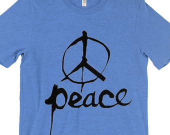 Könnte beinhalten: Ein hellblaues T-Shirt mit einem schwarzen Peace-Zeichen und dem Wort "peace" in einer stilisierten Schrift.