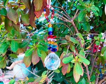 May include: A crystal suncatcher with a clear crystal ball and a beaded chain with red, orange, yellow, green, blue, and purple beads.