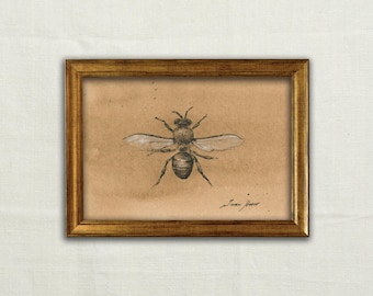 Könnte beinhalten: Eine gerahmte Kohlezeichnung einer Biene auf beigefarbenem Papier. Das Insekt ist mit detaillierten Flügeln und Körpersegmenten dargestellt. Das Kunstwerk befindet sich in einem goldfarbenen Metallrahmen mit schlichtem Profil. Signatur Juan Bose.