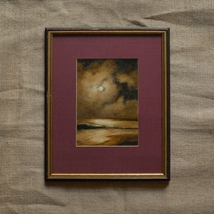 May include: A framed painting of a seascape with a full moon in the sky. The painting is done in shades of brown and gold, with a dark blue sky. The moon is a bright white circle in the center of the painting.