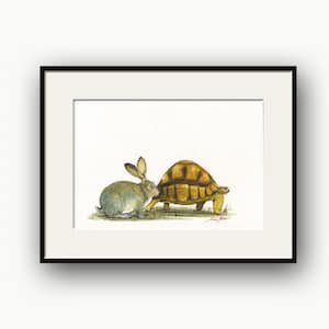 May include: Watercolour painting of a rabbit and a tortoise. The rabbit is light grey with long ears, and the tortoise has a brown shell. They are standing on grass. The artwork is framed in a black frame.