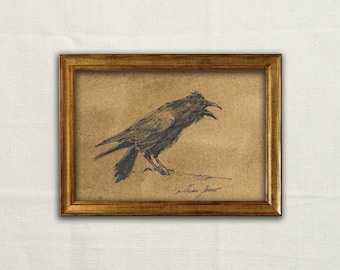 May include: A framed charcoal drawing on tan paper depicting a side profile of a crow with its beak open. The bird is rendered in dark, expressive lines. The artwork is enclosed in a simple, metallic gold-toned frame with a rectangular profile.