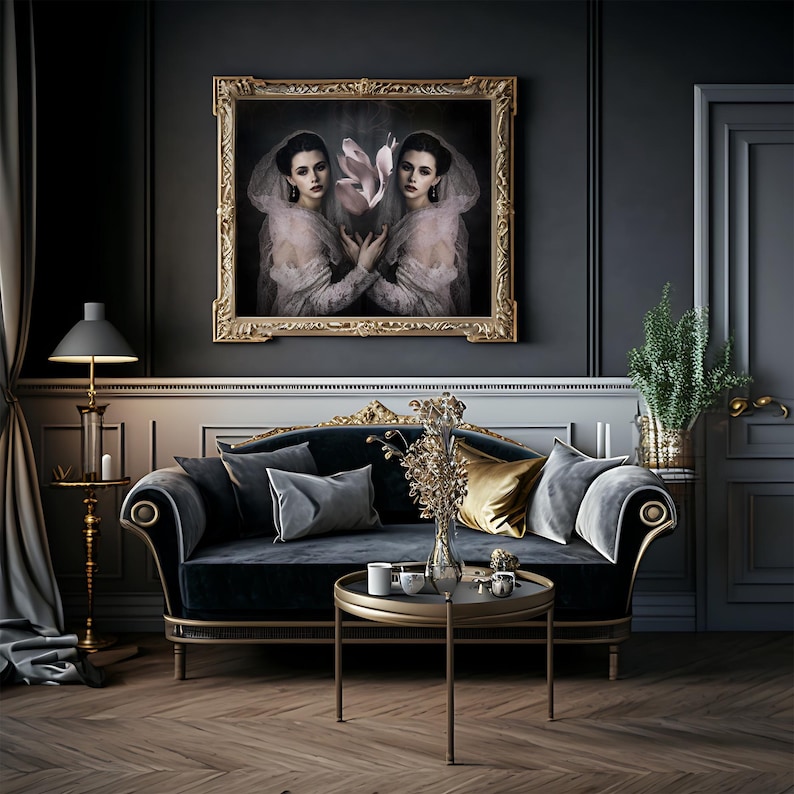 May include: An interior scene featuring a dark blue velvet sofa with gold trim, adorned with gray and gold pillows. A round gold table holds decorative items. A framed portrait with a gold frame hangs above the sofa. A floor lamp and a plant in a decorative vase complete the elegant setting.