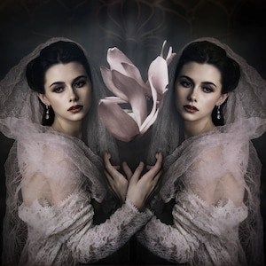 May include: A mirrored image of a woman in a white lace dress and veil, holding a large pink flower. The woman has dark hair, red lipstick, and is wearing drop earrings. The background is dark with a floral design.