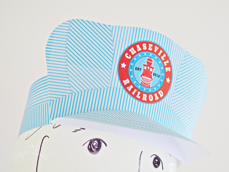 May include: A blue and white striped paper hat with a red and white circle logo that says "Chaseville Railroad Est. 2012".