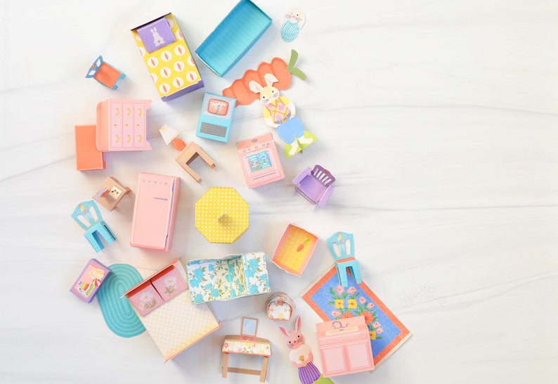 May include: A set of colorful paper dollhouse furniture, including a bed, dresser, stove, refrigerator, table, chairs, and a sink. The furniture is decorated with floral patterns and polka dots.