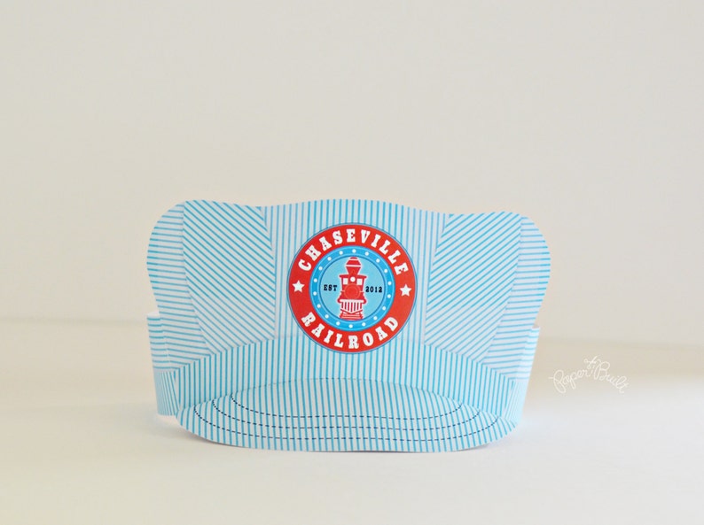 May include: A blue and white striped paper hat with a red and white circle logo that says "Chaseville Railroad Est. 2012".