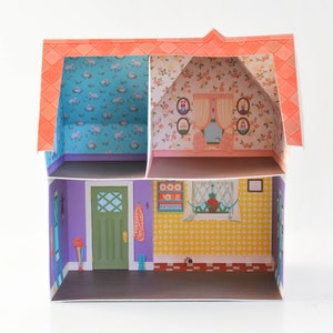 May include: A paper dollhouse with two rooms. The top room has pink and white floral wallpaper and a window with curtains. The bottom room has a purple door, a yellow wall with a window, and a green wall with a coat rack.