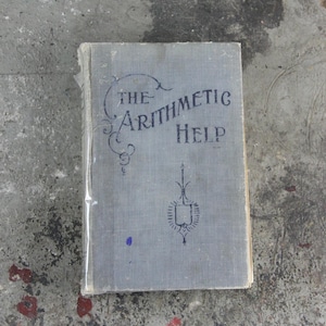 Może przedstawiać: Antyczna, szara książka w oprawie płóciennej z tytułem "The Arithmetic Help" wydrukowanym czarnym atramentem. Książka ma ozdobny wzór na okładce.