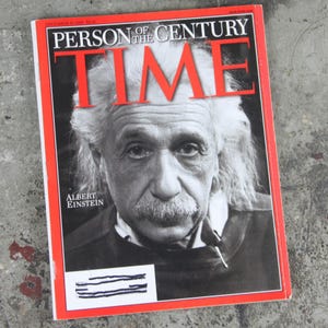 May include: A December 31, 1999 issue of TIME magazine featuring a black and white portrait of Albert Einstein on the cover. The bold red border frames the text Person of the Century and the magazine title TIME in large white and red lettering.