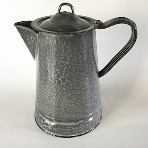 May include: A gray enamel coffee pot with a speckled finish and a lid. The pot has a handle and a spout.