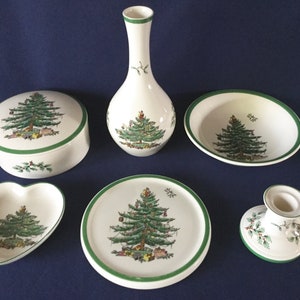 May include: A set of six white ceramic Christmas tree themed items, including a vase, a bowl, a plate, a heart-shaped dish, a round box with a lid, and a candle holder.