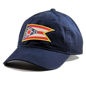 May include: A navy blue baseball cap with a red, white, and blue Ohio state flag patch on the front.