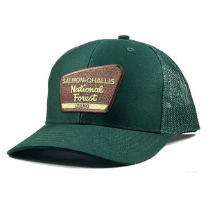 May include: A green trucker hat with a brown patch that says "Salmon-Challis National Forest Idaho".