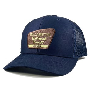 May include: A navy blue trucker hat with a brown patch that reads "Willamette National Forest Oregon".