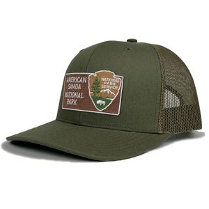 May include: A green and brown trucker hat with a patch that says "American Samoa National Park" and "National Park Service".