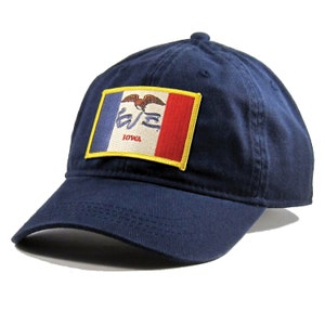May include: A navy blue baseball cap with a yellow, red, and blue embroidered patch featuring the state flag of Iowa. The patch has the words "Iowa" written on it.