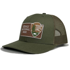 May include: A green and brown trucker hat with a patch that says "Denali National Park" and "National Park Service".