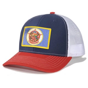 May include: A navy blue and white trucker hat with a red brim. The hat features a patch of the Minnesota state seal.