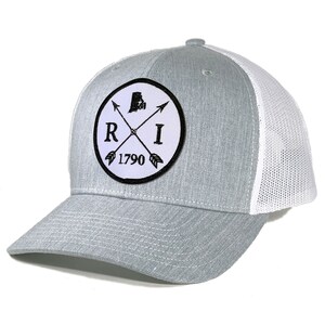 May include: A gray and white trucker hat with a black and white patch featuring the state of Rhode Island, the letters "RI", and the year "1790".