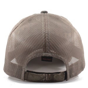 May include: A brown mesh baseball cap with a camouflage adjustable strap and the word "REALTREE" in red on the back.