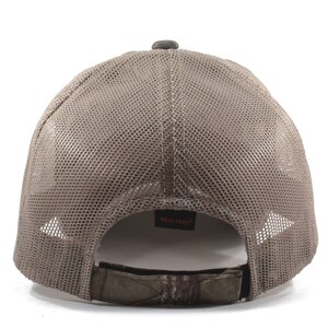 Peut inclure: Une casquette de baseball en maille marron avec une sangle réglable camouflage et le mot "REALTREE" en rouge au dos.