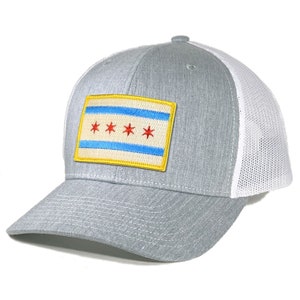 May include: A gray and white trucker hat with a patch of the Chicago flag on the front. The flag is red, white, and blue with four red stars.