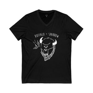 Puede incluir: Camiseta negra con cuello en V con un gráfico blanco de una cabeza de bisonte y un pájaro, con el texto "BUFFALO + SPARROW" encima. El diseño es de estilo sencillo y dibujado a mano.