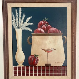 May include: A framed painting of a still life with a vase of white wheat, a bowl of red apples, a red apple on a table, and a small bird on a stand. The painting is signed "Thomas Pell".