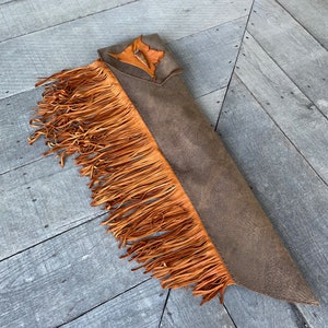 May include: A white ceramic mug with a black handle and the text "But First, Coffee" in a bold, black font. The mug is set against a neutral background, highlighting its simple design.