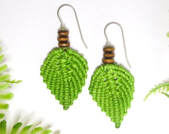 May include: Green leaf-shaped earrings with brown wooden beads and silver hooks.