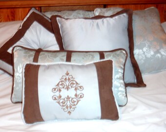 Juego de 3 almohadas decorativas para cama en azul polvoriento y marrón.