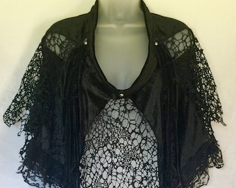May include: Black velvet and lace shawl with fringe detailing. The shawl has a high neckline and a loose fit.