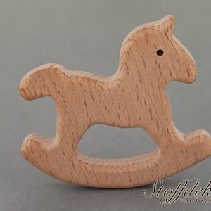 May include: A wooden rocking horse toy made from beech wood. The toy is unfinished and has a natural wood color. The toy is safe for babies and toddlers and is certified by the FSC and DIN EN 71-3.