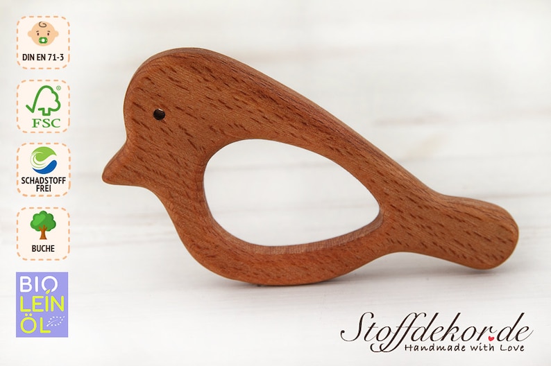 May include: A wooden bird-shaped teether for babies. The teether is made of beech wood and is finished with natural bio-linseed oil. It is certified as safe for babies and is made with sustainable materials.