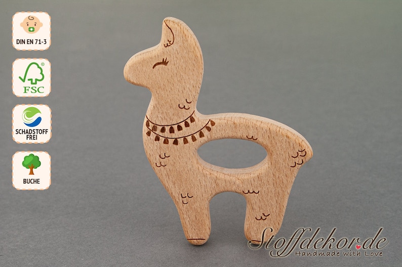 May include: A wooden llama teether with a brown and white design. The teether is made of beech wood and is safe for babies. The teether is shaped like a llama with a long neck and a small head. The teether has a small hole in the middle for a baby to hold onto.