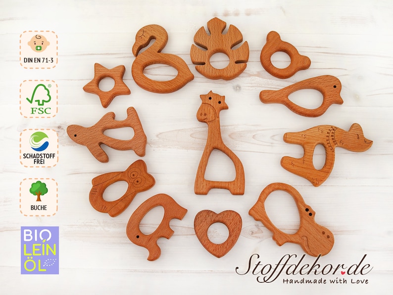 May include: A set of 12 wooden teethers shaped like animals, including a giraffe, a bird, a hippopotamus, a turtle, an elephant, a star, a leaf, and a heart. The teethers are made of natural wood and are safe for babies to chew on. DIN EN 71-3, FSC, Schadstoff Frei, Buche, Bio Lein Ol.