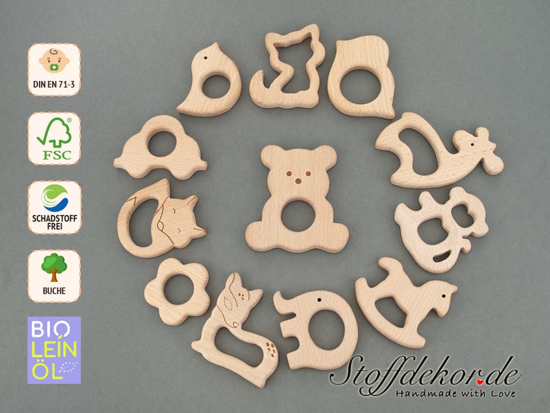 May include: A set of 12 wooden teethers shaped like animals, including a bear, a bird, a deer, a fox, a horse, and an elephant. The teethers are made of natural beech wood and are safe for babies. DIN EN 71-3, FSC, Schadstoff Frei, Buche, Bio Lein&ouml;l.