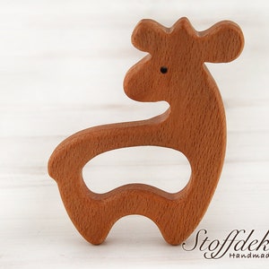 May include: Wooden deer-shaped teether for babies. The teether is made of natural beech wood and is finished with bio-based linseed oil. It is certified safe for babies and is free of harmful substances.