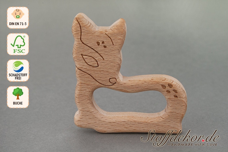 May include: A wooden fox-shaped teether for babies. The teether is made of natural beech wood and is safe for babies to chew on. It is also certified by FSC and Schadstoff Frei.